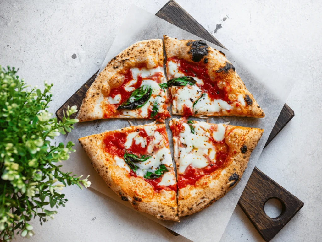 Países con mejor gastronomía. Pizza napolitana recién horneada con masa artesanal, salsa de tomate, albahaca fresca y queso derretido.