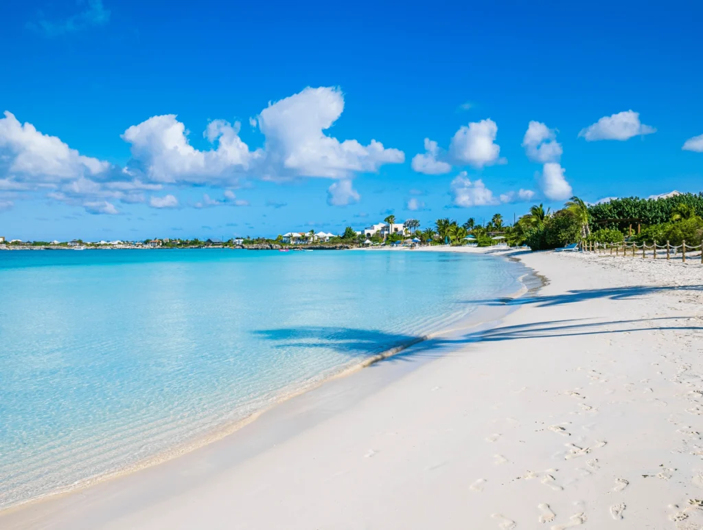 Vista panorámica de Playa Grace Bay con aguas turquesas, arena blanca y un cielo despejado. Es una de mejores playas del mundo!