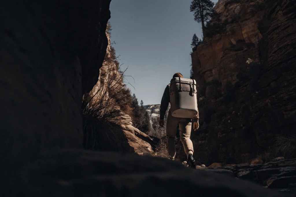 Aventurero con mochila de vacío inteligente en una caminata por montañas y naturaleza.